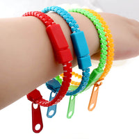 Lot de bracelets à tirette en rouge, bleu, vert et jaune, portés sur un bras pour un usage pratique et ludique