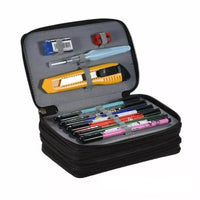 Trousse noire à compartiments, ouverte, contenant des stylos, un cutter et d’autres fournitures scolaires
